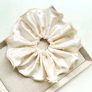 Primer plano de un elegante coletero de satén crema con delicadas decoraciones