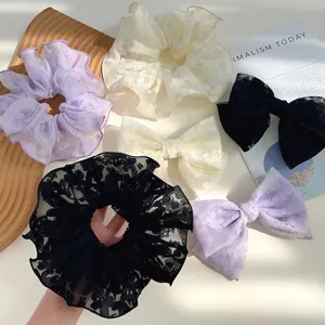 Detailed view of lavender, cream, and black floral lace scrunchies and bows