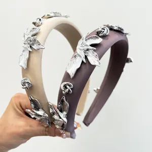 Gros plan de serre-têtes élégants avec fleurs métalliques et texture satinée