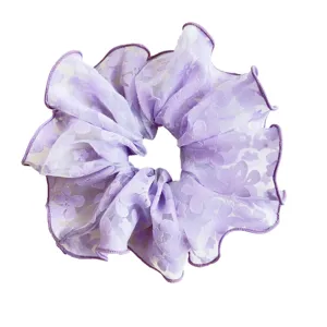 Lavender purple lace scrunchie with delicate floral pattern on a clean white background