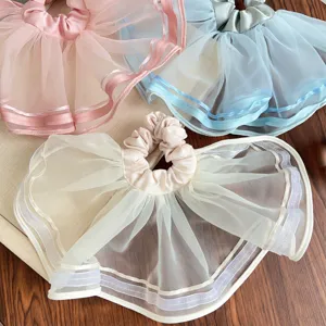 Detailansicht großer Mesh-Organza-Haargummis mit Rüschen in weichen Pastellfarben
