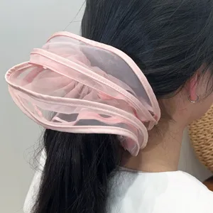 Detailansicht eines rosa Mesh-Scrunchies mit mehrlagigem Plissee-Design am Pferdeschwanz