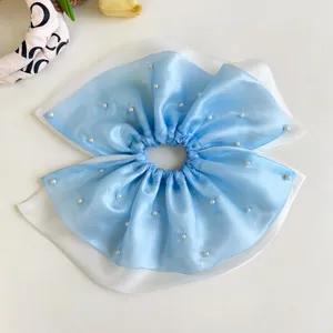 Primer plano de las perlas elegantes de este coletero de malla azul de cuatro capas
