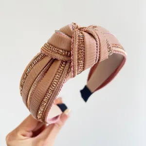 Primo piano dettagliato di un cerchietto annodato rosa con strisce di strass lucide