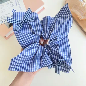 Vista dettagliata di un elastico per capelli a quadretti blu con fiocchi per acconciature.