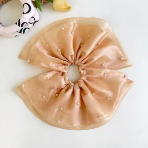 Primer plano de coletero de malla color champán con elegantes detalles de perlas