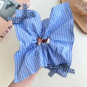 Primo piano di un elastico per capelli oversize a quadretti blu e bianchi con fiocchi