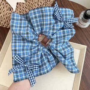Vista dettagliata dello scrunchie a quadri blu con graziosi fiocchi e morbida trama in tessuto