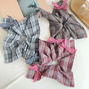 Vista dettagliata di quattro elastici per capelli a quadri stile preppy in vari colori