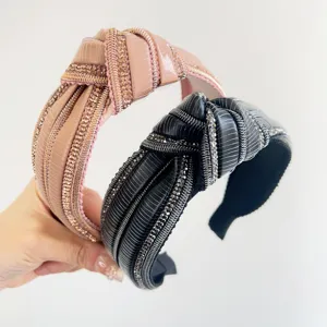 Dettaglio di due eleganti cerchietti con nodo e strass nei colori rosa e nero