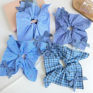 Vista dettagliata di quattro scrunchies a quadretti blu con fiocchi decorativi