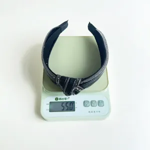 Vista dettagliata di un cerchietto nero annodato con strass che pesa 55g su bilancia