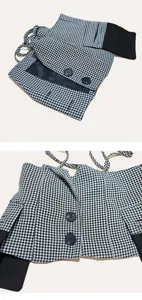 Gedetailleerd overzicht van een zwart-witte houndstooth vetergilet met knopen en stoftextuur.