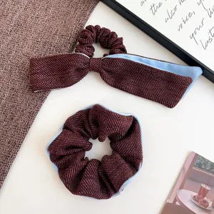 Macro detail of elegant tweed bow hair tie and matching scrunchie with light blue lining
