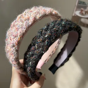 Close-up of thick knitted woolen headbands showing colorful textured weave detail
