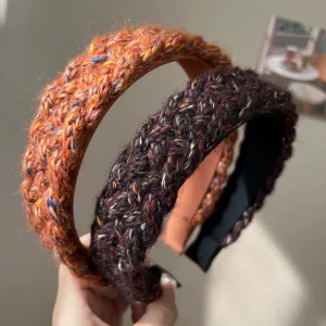 Close-up of mixed color knitted wide-brimmed headbands showing detailed wool texture.