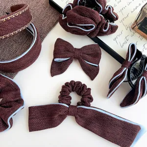 Detailed view of burgundy tweed hair accessory set with headbands and bow hair clips.