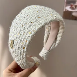 Detailed macro view of white tweed padded headband featuring elegant gold sequins