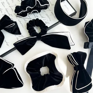 Detailed view of black velvet hair accessory set featuring elegant white piping trim