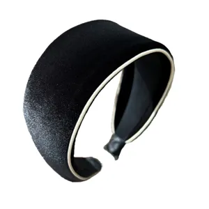 Black velvet padded sponge headband with white trim and silver glitter detail on white background