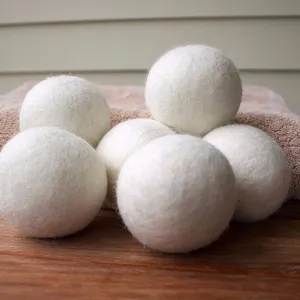 Primer plano de seis bolas de lana orgánica para secadora, cuidado natural de la ropa.