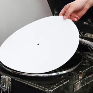 Vista detallada de un tapete protector blanco para tocadiscos de vinilo en la mano