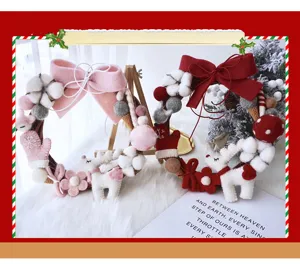 Detailopname van twee vilten kerstkransen in rood en roze met rendierdecor