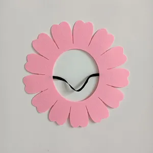 Macro view of pink felt sunflower headpiece showing material and elastic band