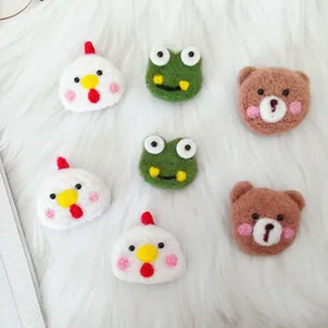 Detailansicht von handgefertigten Nadelfilz-Tier-Accessoires: Huhn, Frosch und Bär