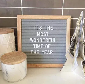 Detail eines quadratischen grauen Filz-Letterboards mit Holzrahmen und Text.
