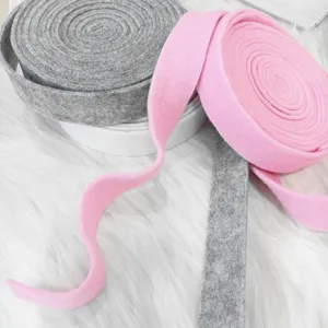 Zachte wolvilten lintrollen in roze en grijs voor DIY kerstboomversieringen en knutselen.