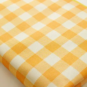 Detailed view of yellow and white checkered waterproof outdoor picnic mat fabric texture.