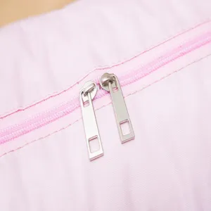 Close-up detail of durable pink travel storage bag zipper and smooth metal pullers.