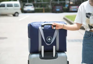 Foldable travel duffel bag luggage sleeve detail showing portable storage design outdoors view.