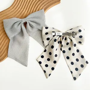 Détail de barrettes à cheveux à pois montrant le mécanisme de clip à ressort sur fond blanc