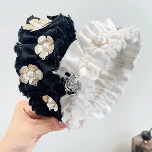 Gedetailleerd overzicht van gerimpelde haarbanden met metalen bloemen en parels