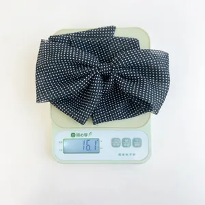 Détail montrant le design léger de 16,1 g de cette pince à cheveux à nœud à pois