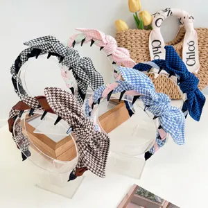 Detailed view of multiple vintage houndstooth rabbit ear headbands with teeth combs