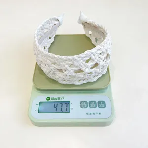 Detailed view of a white braided headband weighing 47.7 grams on a scale.