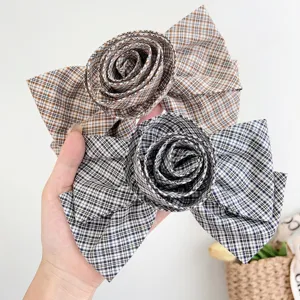 Dettaglio delle mollette per capelli in tessuto a quadri con centro a rosa 3D unico