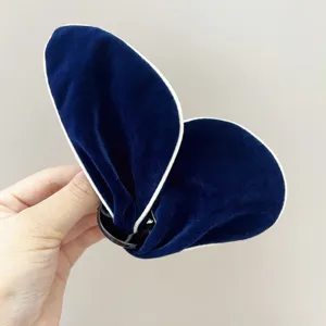 Vue détaillée de la pince à cheveux papillon en velours bleu marine avec bord blanc
