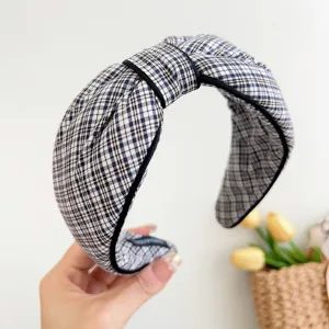 Detailansicht eines stilvollen blau-weißen karierten Knotenstirnbands für Damen.