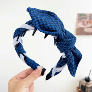 Detail showing the blue houndstooth bow and twisted design on a stylish headband