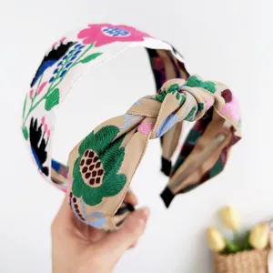 Vue détaillée de la broderie florale bohème sur un bandeau noué large et élégant.