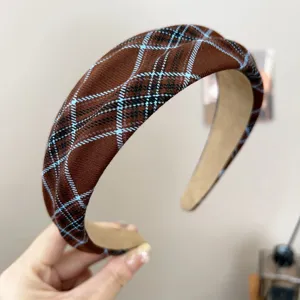 Detailed macro view of vintage brown plaid wide headband with soft fabric texture