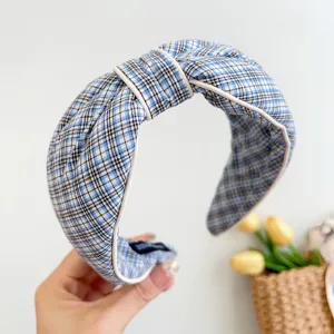Detailansicht eines blau-weiß karierten Haarreifens mit elegantem Knotendesign.