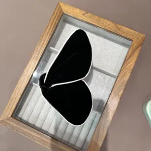 Vue détaillée d'une élégante pince à cheveux papillon en velours noir avec liseré blanc