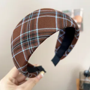 Close-up of a wide vintage brown plaid fabric headband with elegant blue and white stripes