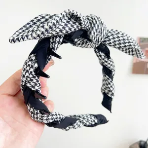 Close-up of houndstooth rabbit ear headband with braided texture and inner teeth.