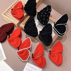 Détail de diverses pinces à cheveux papillon en velours avec accents de perles et strass.